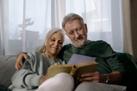 A retired man and woman reading a book